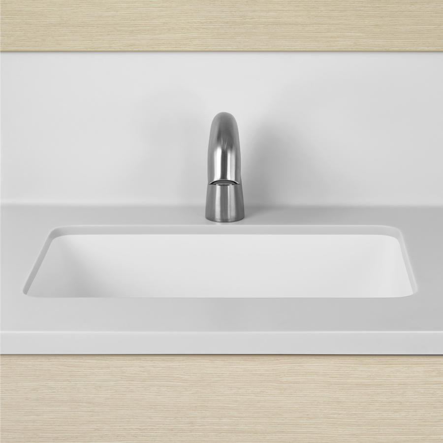 A close-up view of a Mora Casework integrated sink and backsplash in white solid surface.