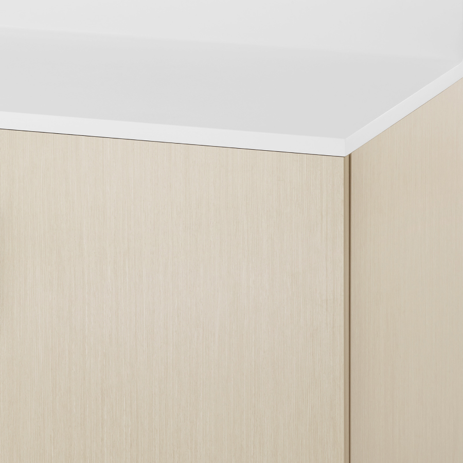 A close-up view of a Mora Casework cabinet in a light wood finish and white Corian surface.