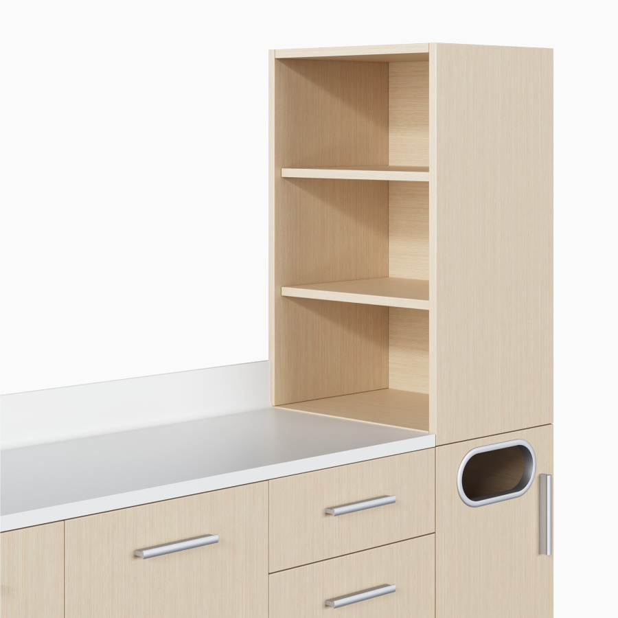 A close-up view of a Mora Casework storage unit tower in an ash wood finish with open shelves.