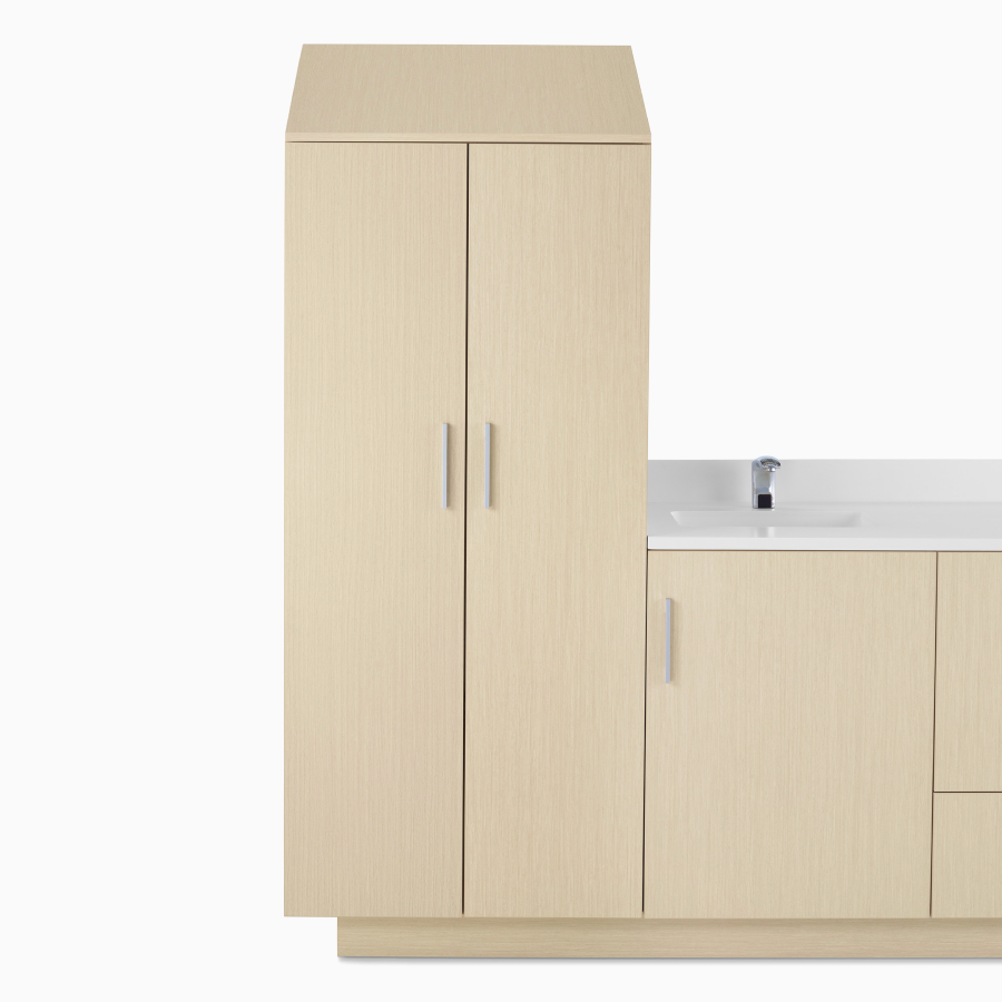 A close-up view of a Mora Casework to-the-floor storage tower in a light wood finish.