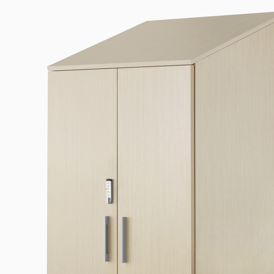 A Mora Casework tower storage cabinet with keyless locking door in a light wood finish.