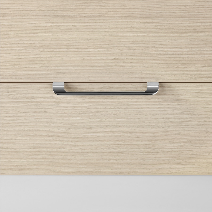 A close-up view of a curved pull on a Mora Casework storage drawer in an ash wood finish.