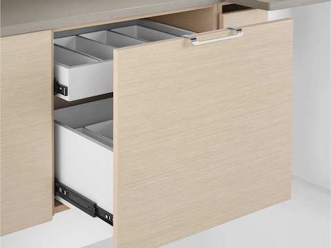 Close view of an open drawer on a Mora System base cabinet, showing interior compartments to organize supplies.
