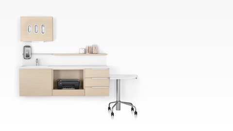 Wall-mounted Mora System clinical casework, including an overhead glove dispenser, sink, and printer compartment. 