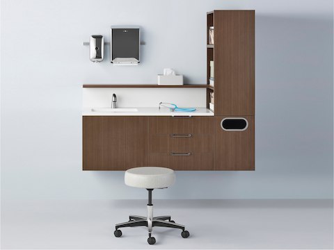 Mora System casework in a dark wood finish with one physician stool in light textile.
