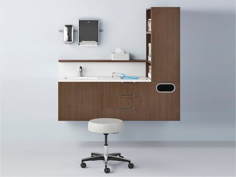 Mora System casework in a dark wood finish with one physician stool in light textile. Mora System casework in a dark wood finish with one physician stool in light textile.