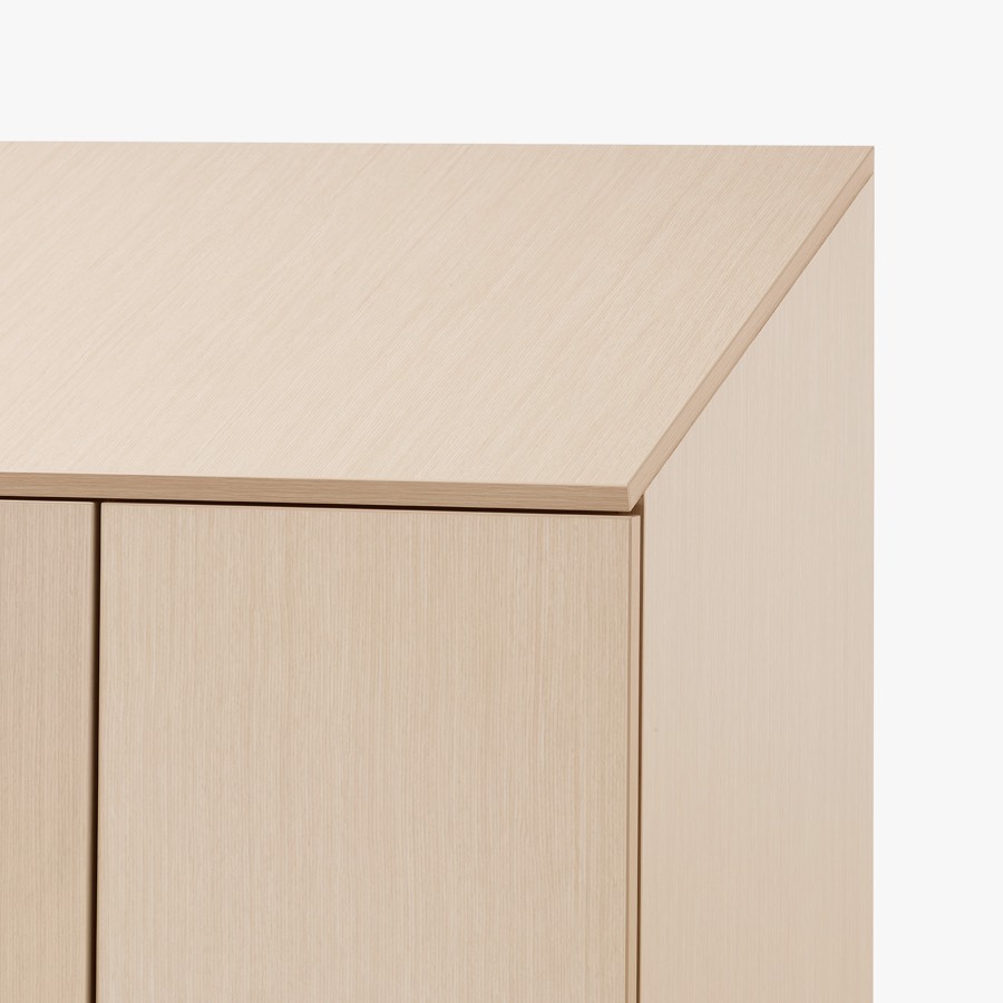 A close-up view of Mora System casework in a light wood finish with a sloped top for better cleaning.