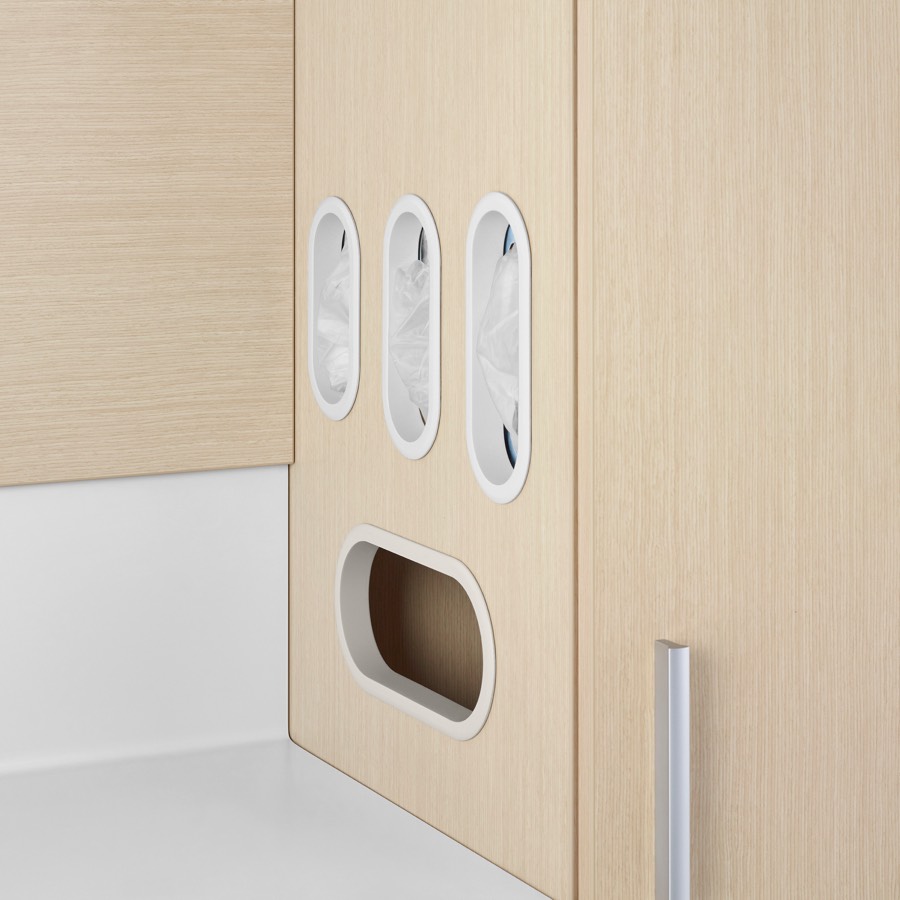 A close-up view of Mora System casework in an ash wood finish with glove storage and trash disposal.