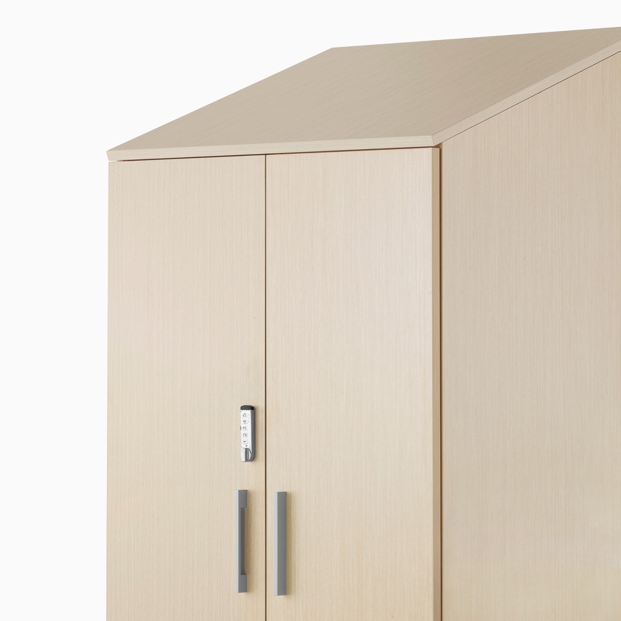 A Mora System tower storage cabinet with keyless locking door in a light wood finish.