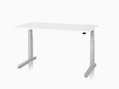 A white Motia Sit-to-Stand Table, viewed from a 45-degree angle. A white Motia Sit-to-Stand Table, viewed from a 45-degree angle.
