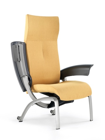 Angled view of a mustard-coloured Nala Patient Chair with one arm pivoted back for easier patient access.