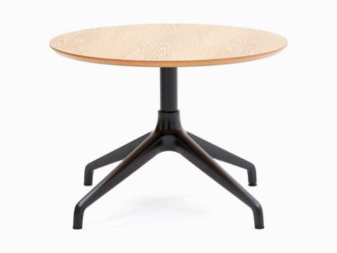 Una mesa de Café Ali de NaughtOne, con base de estrella de 4 puntas en negro y superficie de chapa de madera circular en roble.