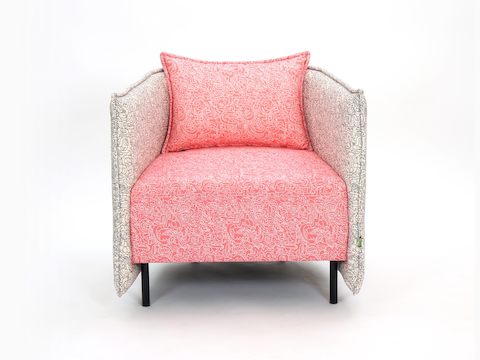 A naughtone Cloud Plain Armchair with intricately pattered fabric in two colors:  a cream and gray surround and coral seat and seatback.