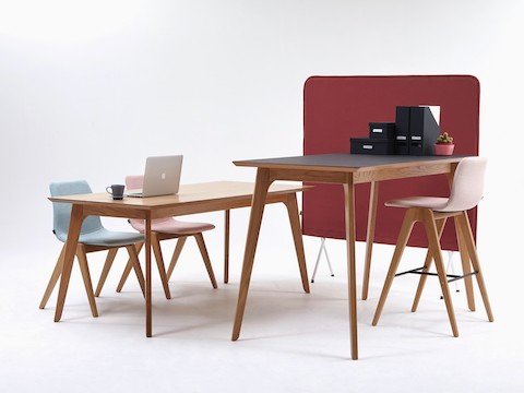 Una mesa Dalby con altura de bar, superficie en negro y patas de madera, junto a un taburete de madera Viv. También, aparece en la imagen una mesa de conferencias Dalby con dos sillas de madera Viv.
