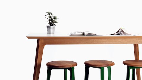 Dalby吧台桌，配有木制桌腿和白色桌面，旁边是三张吧台高度的Construct凳子。