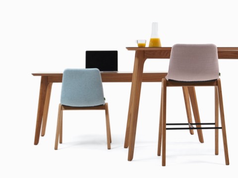两张Dalby会议桌，其中一张搭配Viv木制座椅，另一款吧台高度的会议桌则搭配Viv木制凳子。
