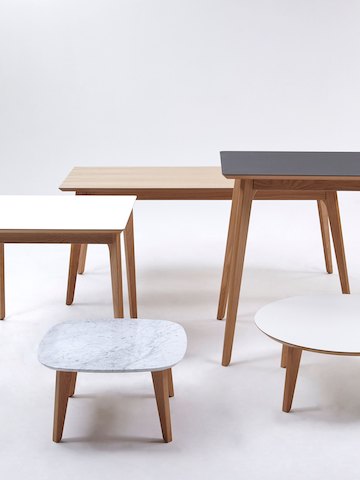一张配有木制桌面的NaughtOne Dalby会议桌，后面摆放着一组Dalby系列的其他桌子。