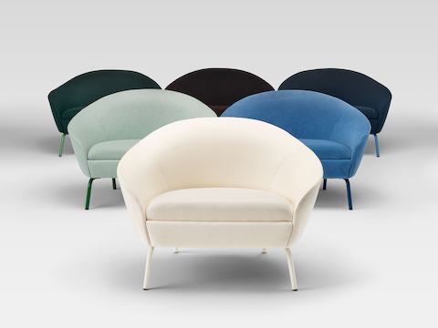 Een groepsbeeld van verschillende Ever Lounge-fauteuils, in een verscheidenheid aan gedempte stoffenkleuren.