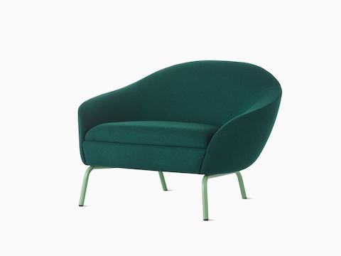 Vista en ángulo frontal de un sillón lounge Ever tapizado en verde oscuro con patas de acero en verde pálido.