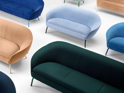 Groupe de meubles incluant le fauteuil lounge Ever et une collection de canapés en tissu aux couleurs feutrées.