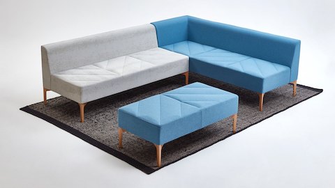 A gray and blue NaughtOne Hatch Modular Seating units and a blue Hatch Bench placed over a single rug.