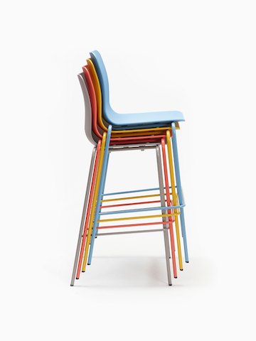 A tan, orange, yellow and blue Polly Stool stacked upon one another, viewed from the side.