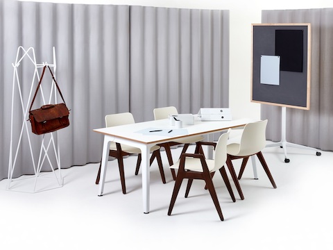 Fünf cremeweiße Polly Wood Stühle mit Nussholz-Beinen und Armlehnen an einem weißen Fold Konferenztisch.