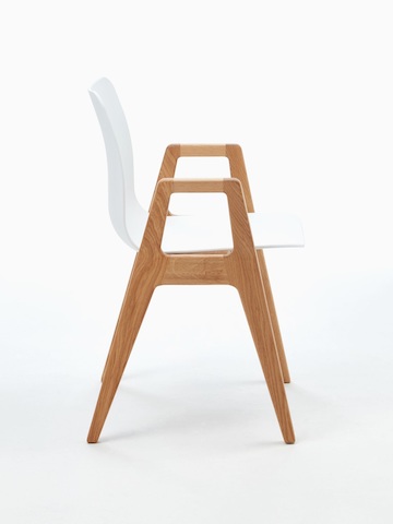 侧视图：白色NaughtOne Polly木制座椅，配有橡木底座和扶手。