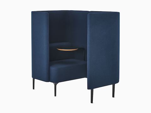 Three-quarter angle of Pullman Chair Pod on black legs, upholstered in a dark blue fabric, with tablet arm and screen to the left.