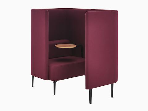 Three-quarter angle of Pullman Chair Pod on black legs, upholstered in burgundy fabric, with tablet arm and screen to the left.