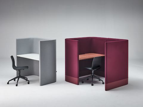 Grey Pullman Desk with black Polly chair, sitting next to burgundy Pullman Desk Pod with Polly chair.