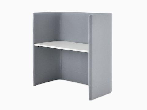An angled view of Pullman Desk upholstered in pale grey fabric, with white mfmdf top.