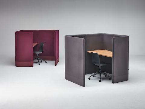 紫红色Pullman舱式办公桌和黑色Polly座椅，摆在旁边的是灰色的Pullman舱式办公桌和黑色Polly座椅。