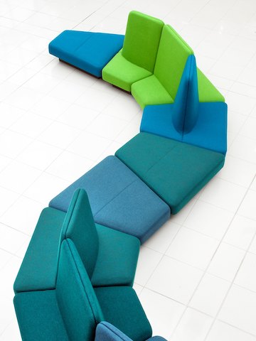 俯视图：Rhyme模块化座椅，带蓝色和绿色色调，蜿蜒穿行于白色的瓷砖地板之上。
