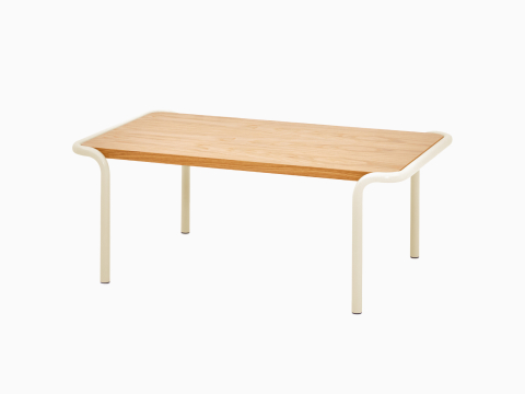 Una vista de ángulo de frente de una mesa rectangular Sweep con cubierta de roble y marco color crema. Una vista de ángulo de frente de una mesa rectangular Sweep con cubierta de roble y marco color crema.