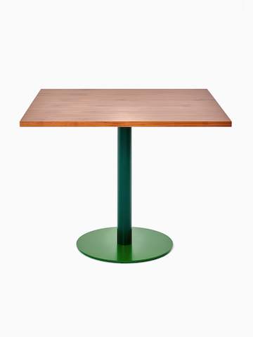 Schrägansicht eines quadratischen Tier Tisches mit einer Platte aus Walnussfurnier, einem moosgrünen Schaft und einem blattgrünen Fußkreuz.