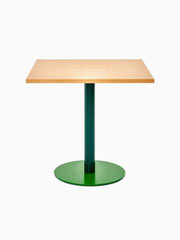 Vista frontale di un tavolo Tier quadrato con piano impiallacciato in rovere, stelo verde muschio e base verde foglia.
