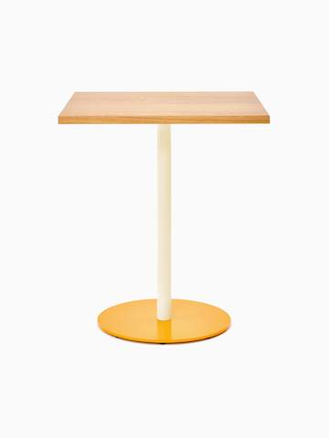 Vue de face d’une table carrée Tier avec un plateau en placage de chêne, une tige gris huître et un piètement jaune paille.