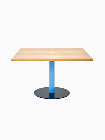 Vorderansicht eines quadratischen Tier Tisches mit einer Platte aus Eichenfurnier, einem pastellblauen Schaft und einem stahlblauen Fußkreuz.