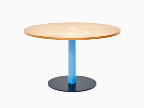 Vue de face d’une table ronde Tier avec un plateau en placage de chêne, une tige bleu pastel et un piètement bleu acier. Vue de face d’une table ronde Tier avec un plateau en placage de chêne, une tige bleu pastel et un piètement bleu acier.