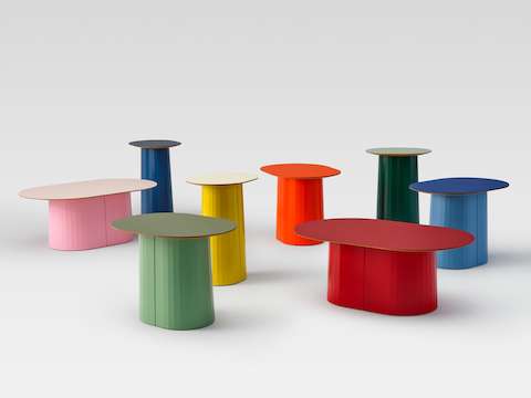 Groupe de meubles incluant un assortiment de huit tables Tun dans diverses couleurs vives.
