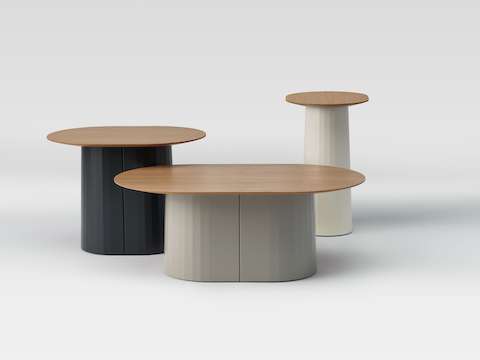 A group scene of three Tun tables in a variety of neutral colors.