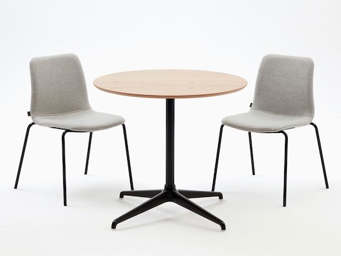 两张搭配灰色织物软垫和黑色4腿底座的Viv单椅，以及搭配橡木胶合板桌面的黑色4星会议桌。