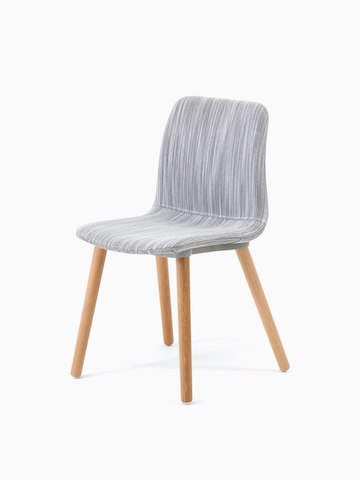 A three-quarter view of a Viv Side Chair upholstered in light grey fabric on oak dowel base.