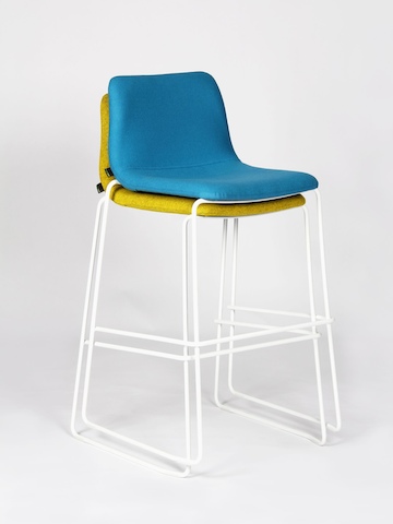 Chaise haute Viv bleue avec piètement en métal blanc empilée sur une chaise haute Viv verte avec piètement en métal blanc, vues sous un angle.