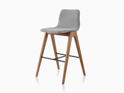 A grey upholstered NaughtOne Viv Wood Stool, viewed at an angle. A grey upholstered NaughtOne Viv Wood Stool, viewed at an angle.