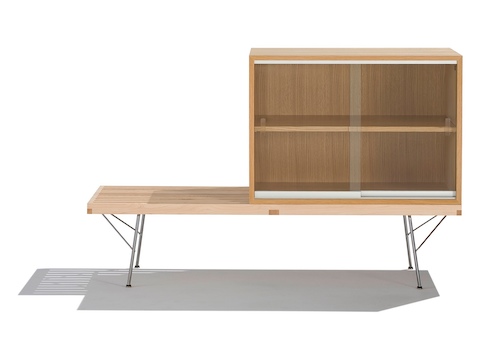 Um módulo de armazenamento Nelson Basic Cabinet Series com uma prateleira e portas de vidro deslizantes fica no topo de uma plataforma Nelson Platform Bench.