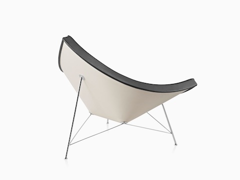 Three-quarter rear view of a black leather Nelson Coconut Lounge Chair, focusing on the white plastic shell.