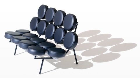 A black leather Nelson Marshmallow Sofa, viewed from a 45-degree angle that includes its shadow.