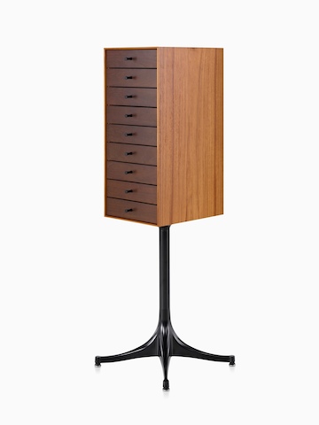 Angled view of a vertical nine-drawer Nelson Miniature Chest with a medium finish and black pedestal base. 